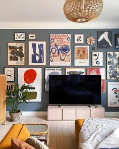 a living room filled with furniture and pictures on the wall above it is a flat screen tv