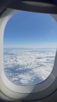 an airplane window looking out at the clouds