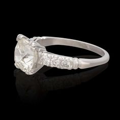 a white gold ring with an oval cut diamond surrounded by small round diamonds on each side