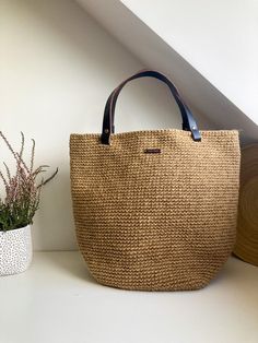 a brown bag sitting on top of a white counter next to a potted plant