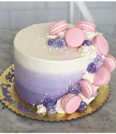 a white cake with purple frosting and pink decorations