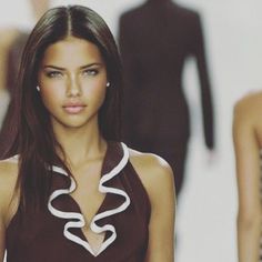 a model walks down the catwalk in a brown and white dress with ruffles