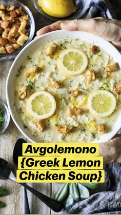 a bowl of soup with lemons and other food on the table next to it