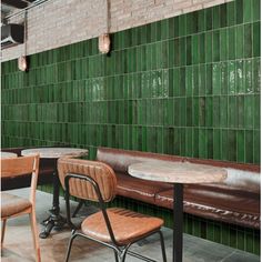 two chairs and a table in front of a green tiled wall