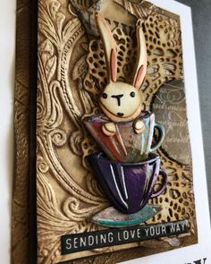 a close up of a card with a bunny in a cup