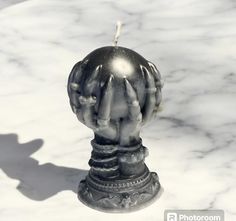 a silver statue with hands on top of it