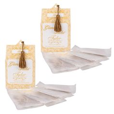 small white paper bags with tassels and tags attached to the top of them