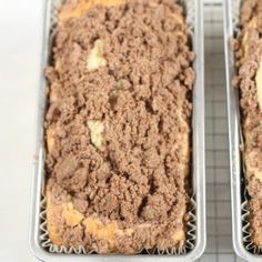 two metal trays filled with food on top of a table