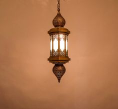 an ornate light fixture hanging from a ceiling in a room with beige walls and flooring