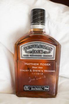 a bottle of whiskey sitting on top of a bed