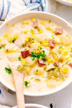 a white bowl filled with potato soup and ham