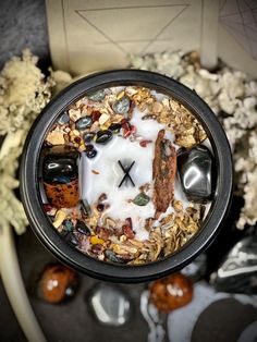 a cup filled with cereal, nuts and other things sitting on top of a table