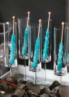 blue candy sticks in wine glasses on a table