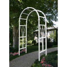 an arched white arbor in the middle of a garden