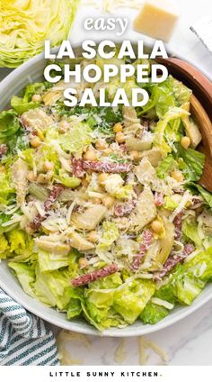 a salad with lettuce, chicken and cheese on top in a white bowl