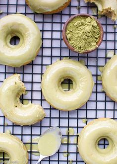 doughnuts on a cooling rack with powdered sugar and spoon next to them