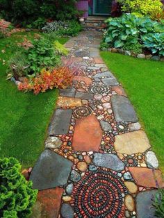 a walkway made out of rocks and stones in front of a purple house with green doors