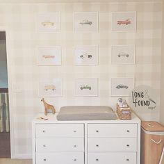 a baby's room with a crib, dresser and pictures on the wall