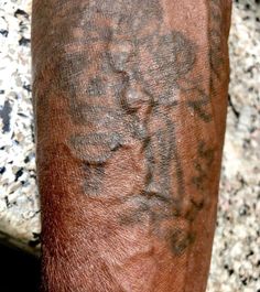 a close up of a person's arm with tattoos on it