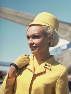 a woman wearing a yellow suit and hat