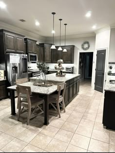 a large kitchen with granite counter tops and dark wood cabinets, along with an island in the middle