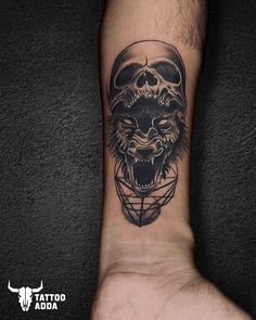 a black and white tattoo with a wolf head on the wrist, in front of a dark background