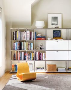 a living room filled with furniture and bookshelves next to a wall mounted book shelf