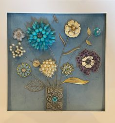 a vase filled with flowers on top of a blue tablecloth covered floor next to a white framed wall