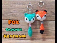 two crocheted keychains are hanging on a wooden surface with the words fox and fish