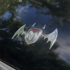 an emblem on the side of a car with bats painted on it's hood