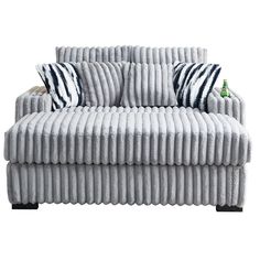 a white couch with black and white striped pillows on it's backrests