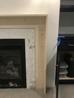 the fireplace is being painted white with blue tape