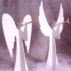 two white angel figurines with trombones in their hands on a gray background