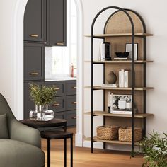 a living room filled with furniture and a book shelf next to a chair in front of a window