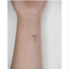 a small tattoo on the wrist of a woman's arm with a single flower