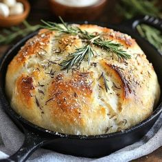 a close up of a bread in a skillet on a table with other food items