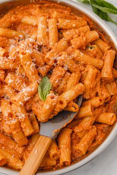 pasta with sauce and parmesan cheese in a skillet on a white table