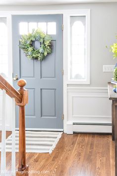 a blue front door with a wreath on it