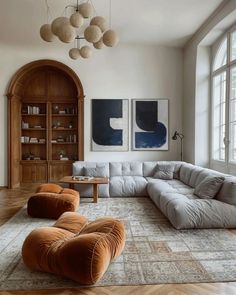 a living room filled with lots of furniture and large open windows on the side wall