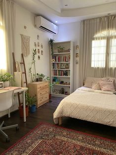 a bedroom with a bed, desk and bookcase in the corner next to a window