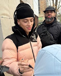 a woman wearing headphones standing next to a man