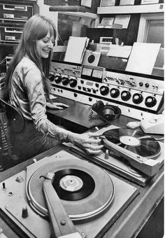 a woman standing in front of a record player