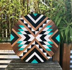 a large wooden plate sitting on top of a wooden table next to a bamboo plant