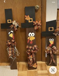 three scarecrows made to look like turkeys with hats and bows on their heads