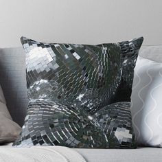 a black and silver throw pillow sitting on top of a couch