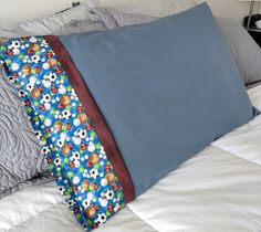 a blue pillow on top of a bed with white sheets and pillows in the background