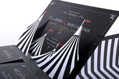 a black and white striped wedding card with gold foil on the front, and an image of a circus tent in the back