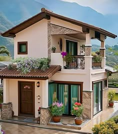 a house with flowers on the windows and balconies above it, in front of mountains