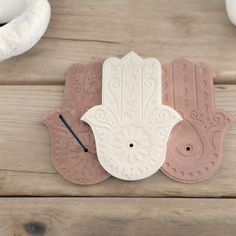 the hamsa wall clock is painted pink and white