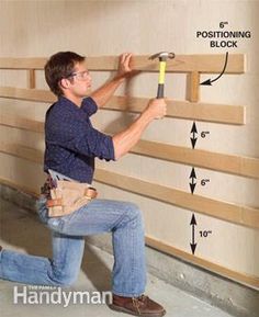 a man is working on some wood planks with a hammer and screwdriver